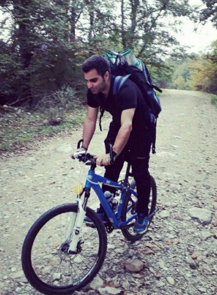 Alireza Khodayarkhani on a mountain bike on a gravel forest trail